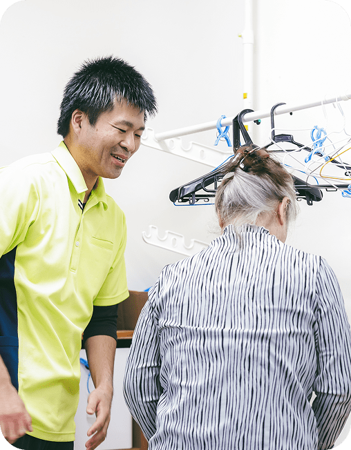 洗濯物干しの介助をするリハビリスタッフ