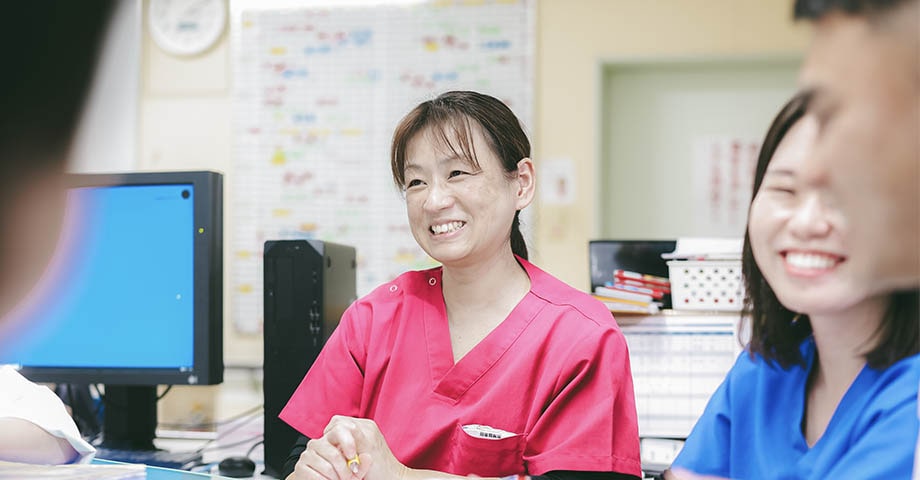 たくさんのスタッフと打ち合わせする女性看護師